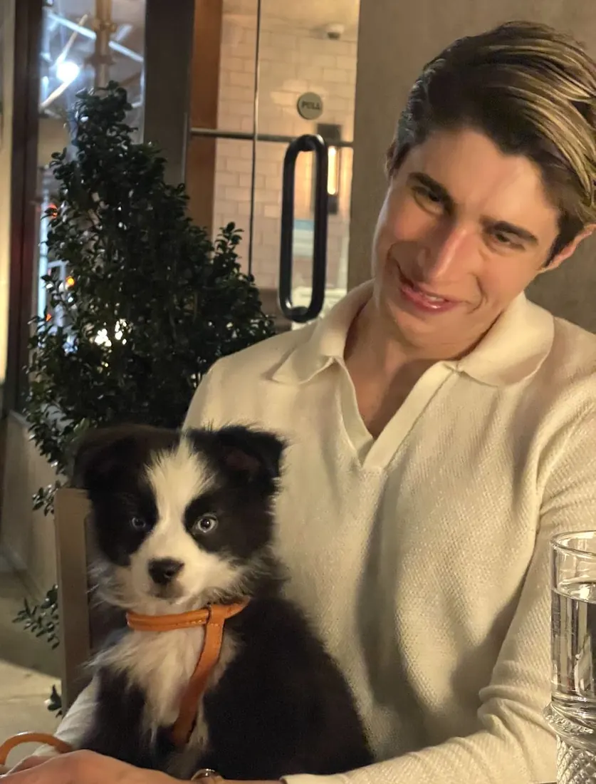 Fluffy at dinner with Charlie, his black-and-white mini Australian Shepherd puppy